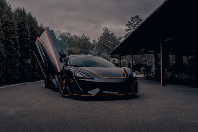 McLaren noire aux portes relevées, ADN Performance Bordeaux